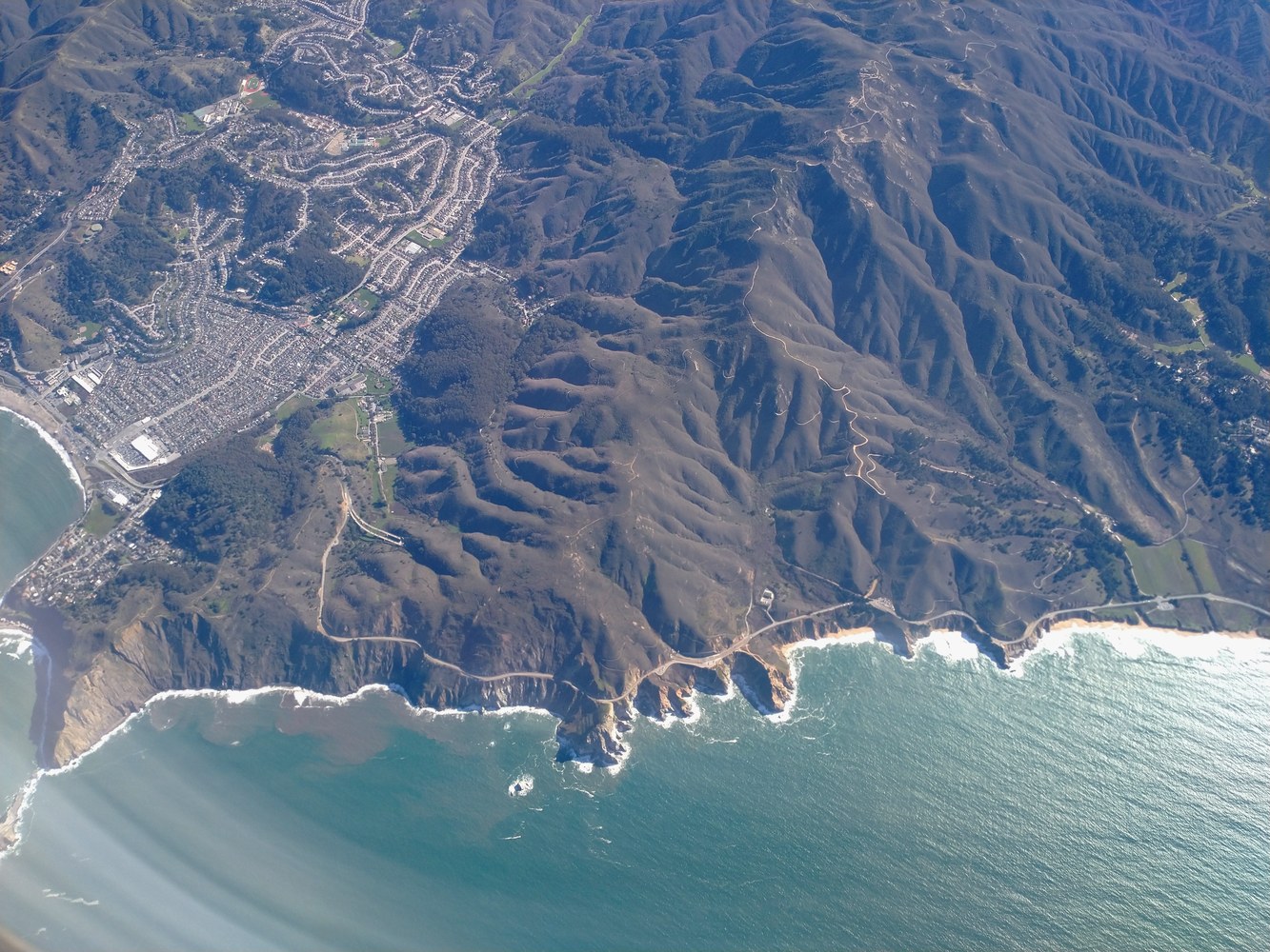 Broad aerial context of the California coast; precise locations are withheld